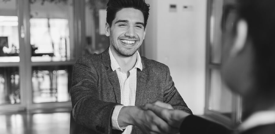 A man in a suit shaking hands with another man