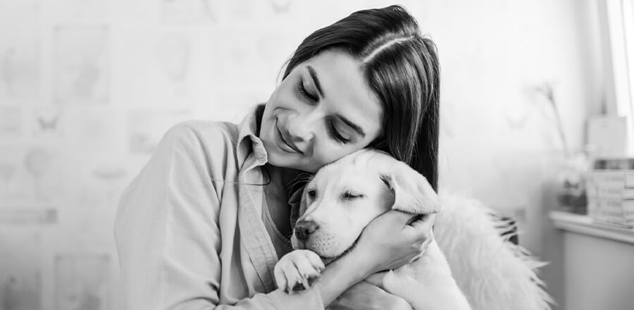 A woman holding a dog in her arms.